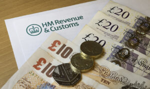 HMRC letter with British pound notes and coins, symbolizing UK tax returns, deductions, and tax savings tips.